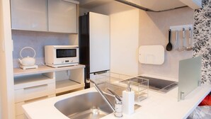 Una cocina moderna con un lavamanos de acero inoxidable, un microondas y un horno empotrado.