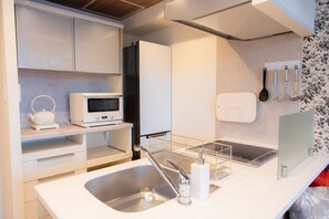 A modern kitchen with a stainless steel sink, a microwave, and a built-in oven. - 1 min walk from sta./Excellent access to central (Osaka)
