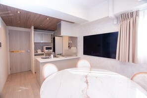 A modern kitchen with white cabinetry, a built-in oven, and a microwave.