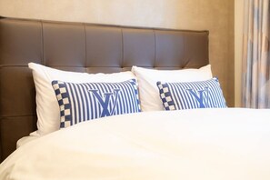 A bed with white bedding and two pillows with a checkered pattern and a large letter 'W'. - 1 min walk from sta./Excellent access to central (Osaka)