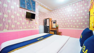 Habitación de hotel con cama, escritorio, armario, televisión y papel tapiz estampado.