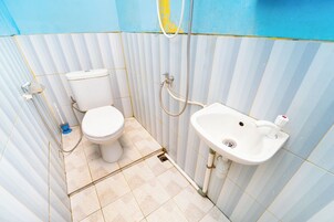 Un baño pequeño con inodoro, lavamanos y ducha.