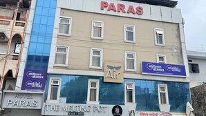 Ett hotell som heter ”PARAS” med en skylt som visar ”THE MELTING POT” och ”motital oswal” på fasaden.