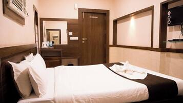 Ein Hotelzimmer mit Bett, Kommode, Spiegel und Fernseher.