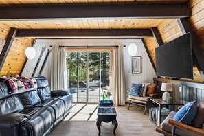 Ein gemütliches Wohnzimmer mit einem Ledersofa, einem Couchtisch und einem Fernseher.