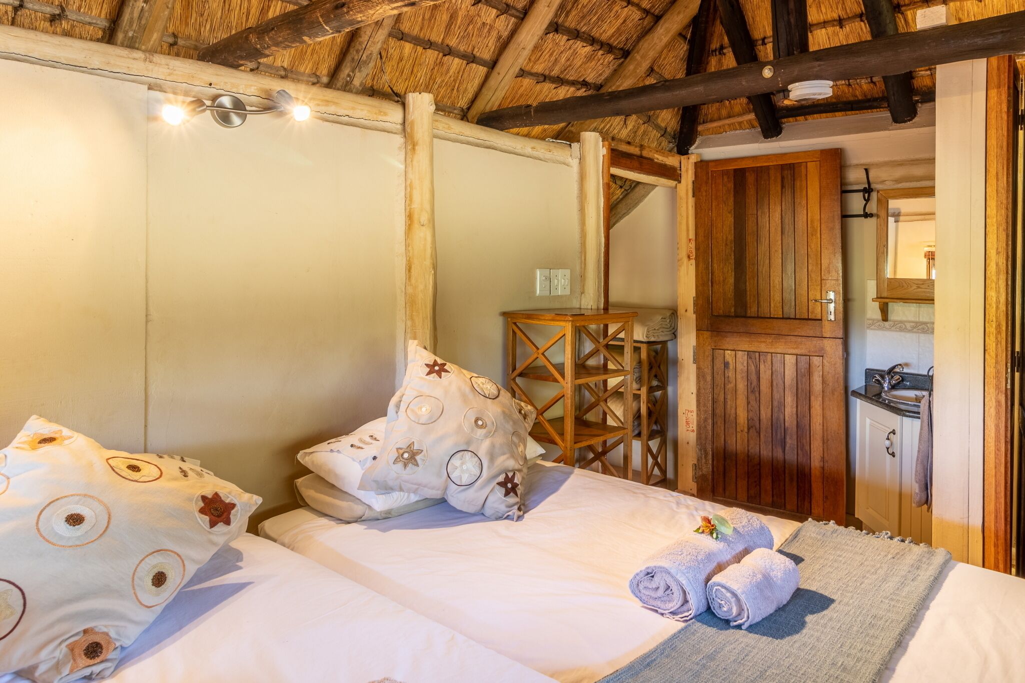 A room with a bed, a wooden door, and a small table.