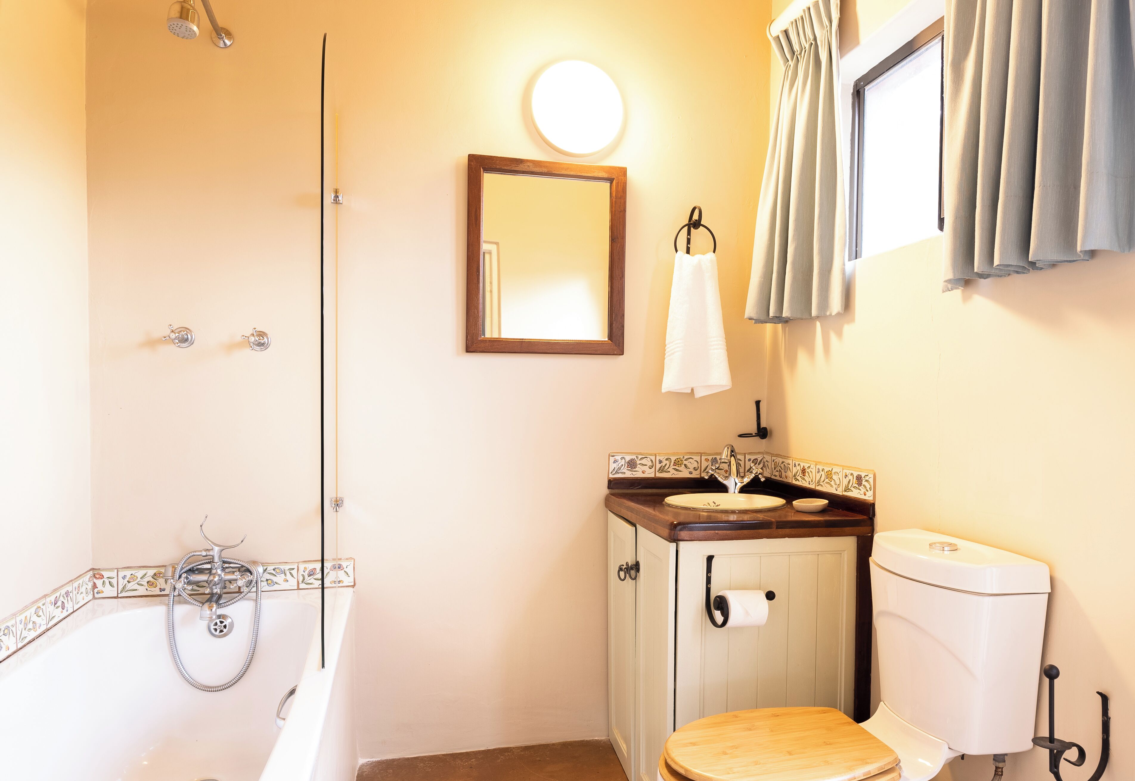 Ein Badezimmer mit einer Badewanne, einer Toilette, einem Waschbecken und einem Spiegel.