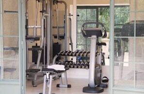 A gym with exercise equipment, including dumbbells and a stationary bike. - Elegant 7 Bedroom Villa, Pool and Panoramic Sea Views (Costa Saracena-Castelluccio)