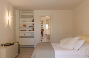 A bedroom with a bed, a bedside table, a wardrobe, and an open door leading to a bathroom. - Elegant 7 Bedroom Villa, Pool and Panoramic Sea Views (Costa Saracena-Castelluccio)