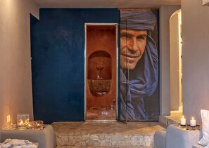 A room with a large painting, a doorway leading to a lit area, and a stone floor. - Elegant 7 Bedroom Villa, Pool and Panoramic Sea Views (Costa Saracena-Castelluccio)