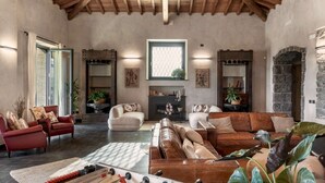 A spacious living room with a high ceiling, a fireplace, and a large window. - Elegant 4 Bedroom Private Pool Villa in Acireale (Acireale)