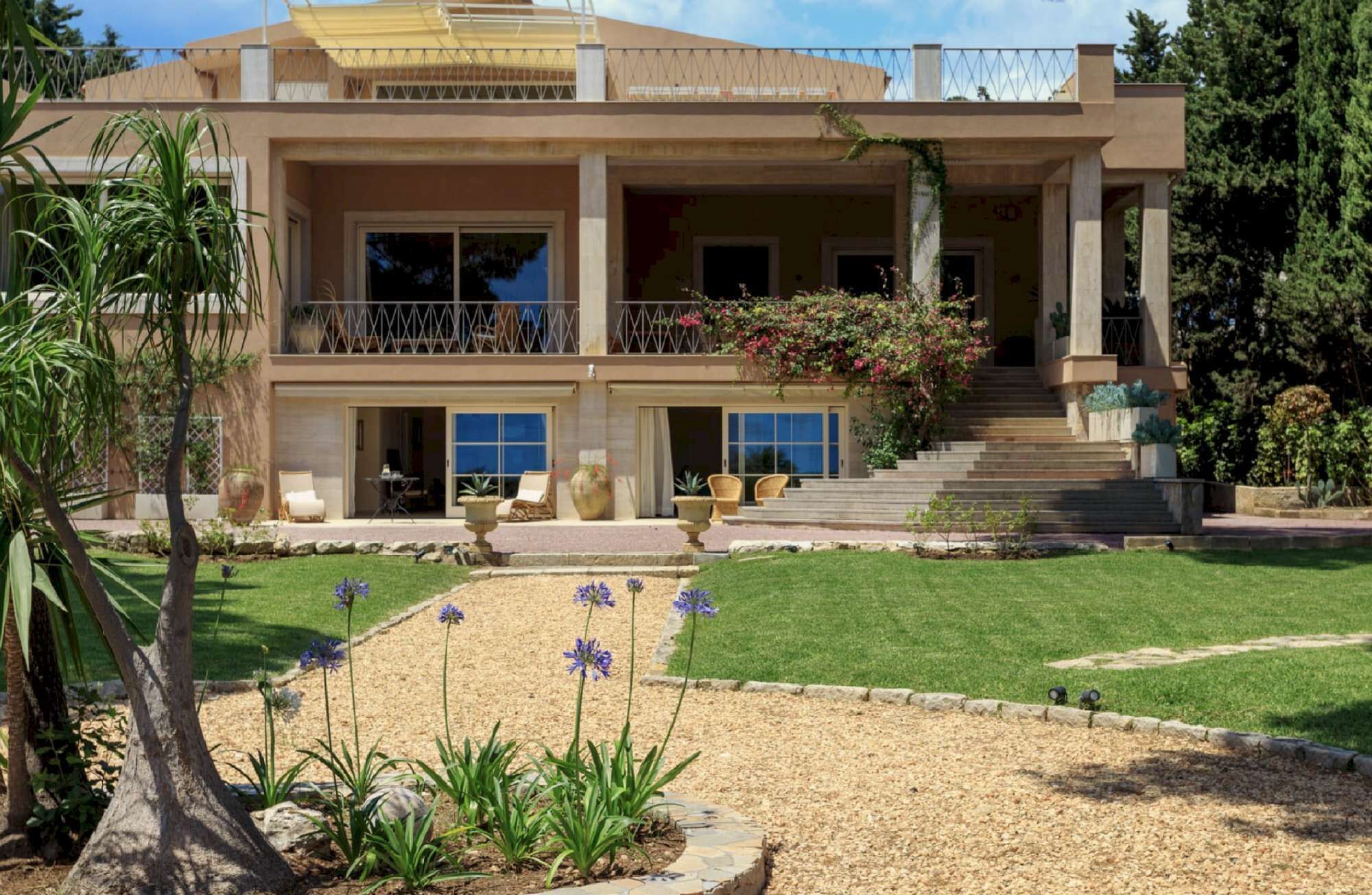 A two-story house with a balcony, a front porch, and a well-maintained lawn.