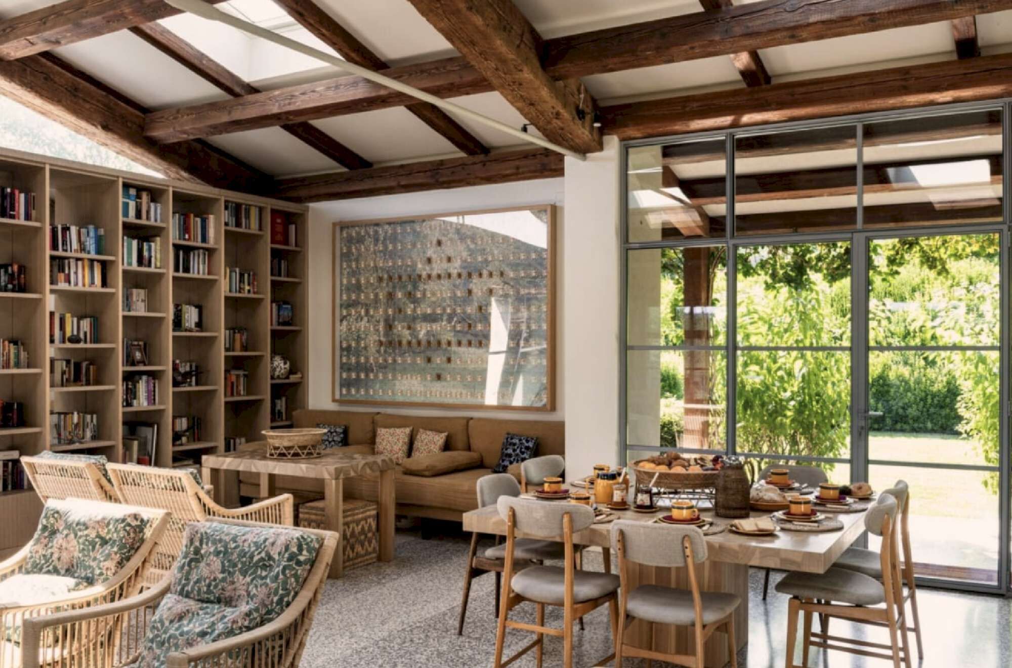 A cozy reading nook with bookshelves, a comfortable sofa, and a dining area with a table set for a meal.