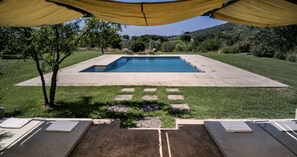 A swimming pool with a surrounding deck and a covered area with a view of the landscape. - Large Orbetello Villa with Private Pool (Orbetello)