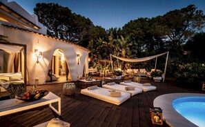 An outdoor patio with lounge chairs, a pool, and a dining area. - Sardinia Dream Getaway: 4BR Villa with Pool & Garden (Santa Margherita di Pula)