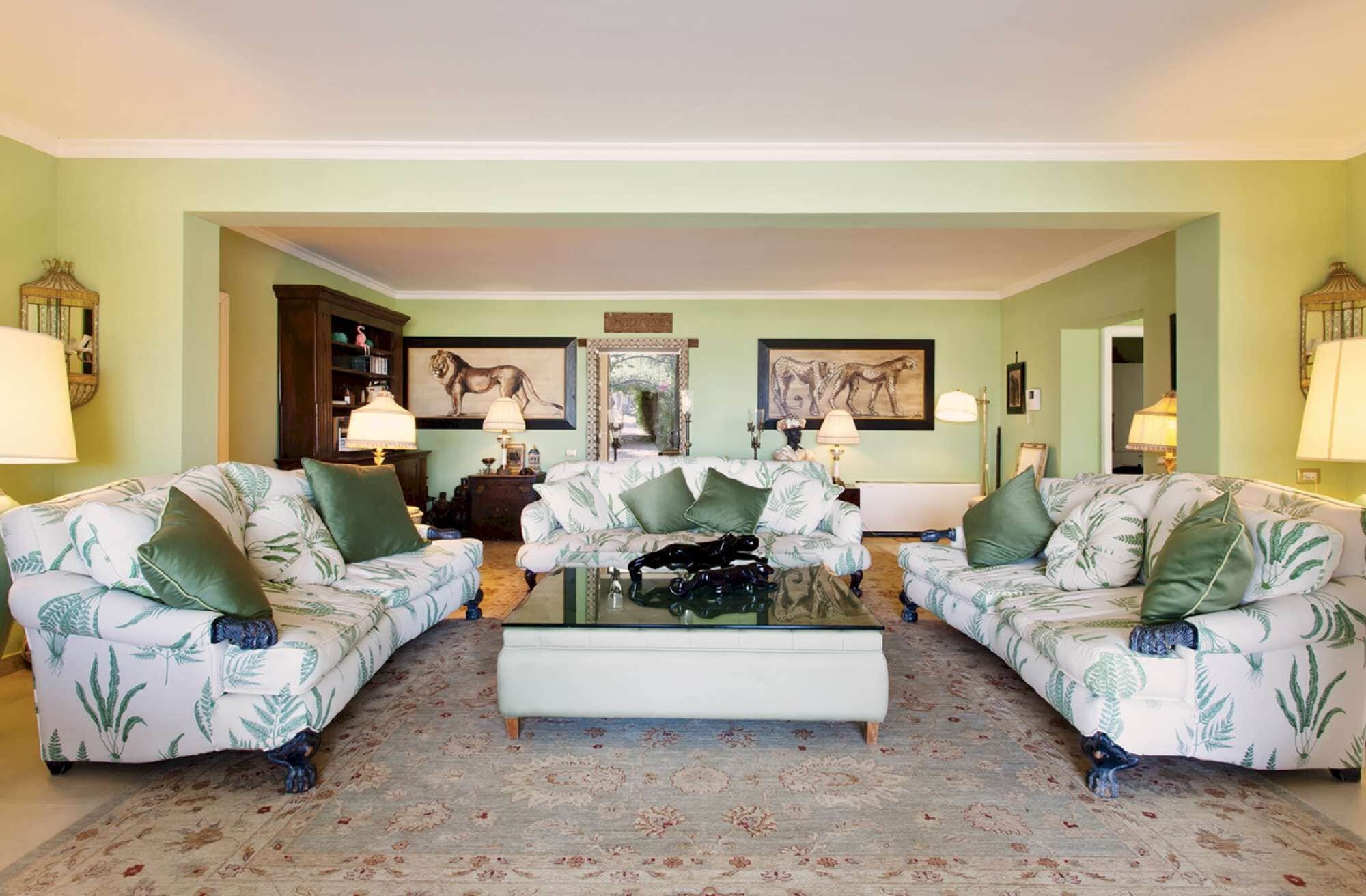 A living room with two sofas facing each other, a coffee table, and a patterned rug.