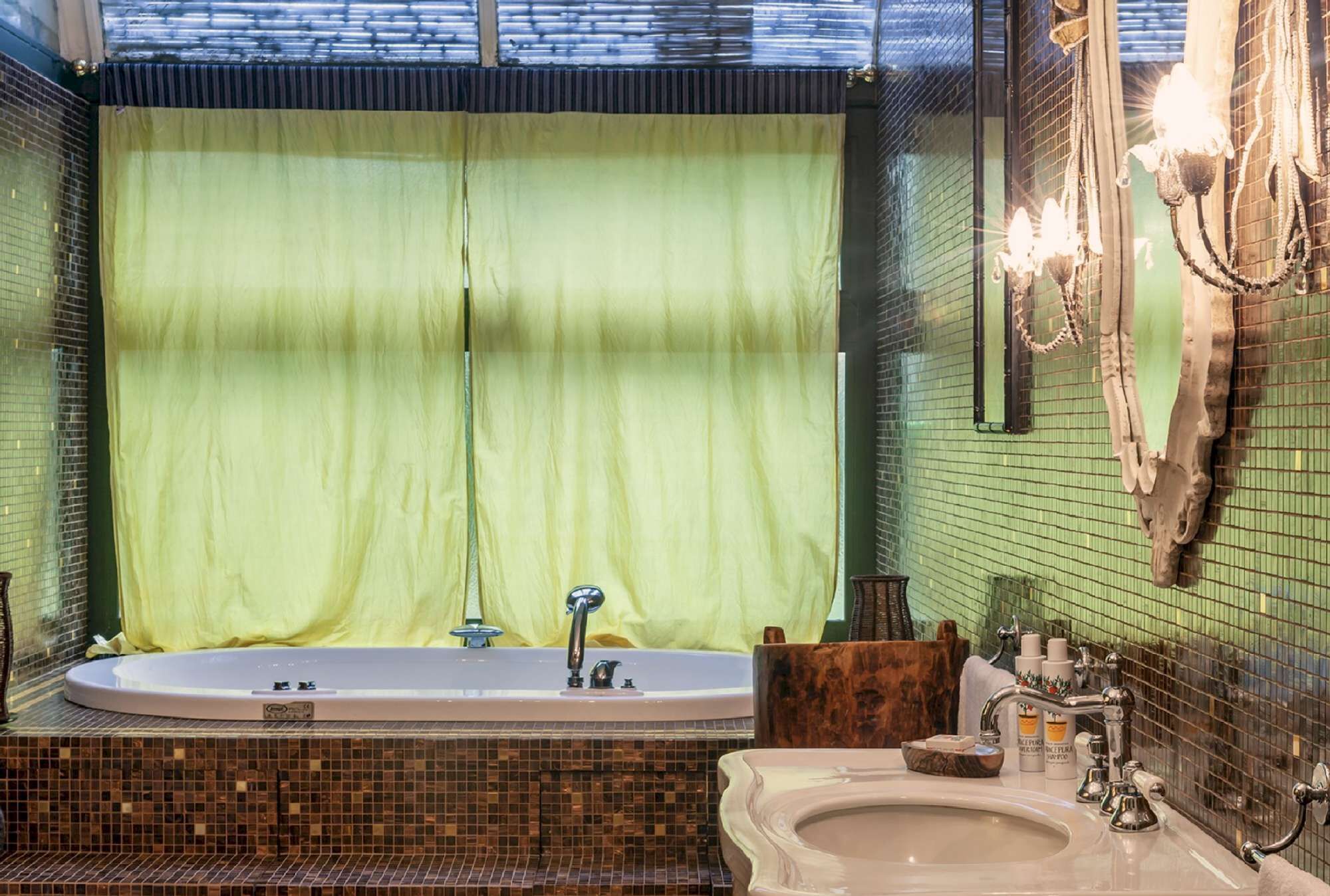 A bathroom with a large bathtub, a sink, and a mirror.