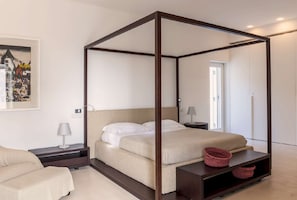 A four-poster bed with a neutral color scheme, a bedside table with a lamp, and a framed picture on the wall. - Exquisite 5BR Villa in Gagliano del Capo, Amazing Garden (Gagliano del Capo)