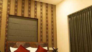 A bedroom with a wooden bed, a headboard, a bedside table, and a curtain.