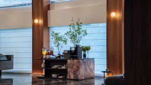 A modern lobby with a reception desk, a coffee machine, and a seating area. - Intercity Hotel Lijiang Dashuiche (Lijiang)
