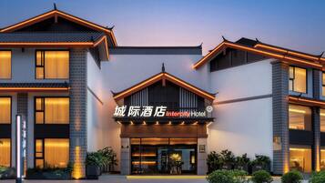 A modern hotel with a prominent entrance, large windows, and a well-lit facade.