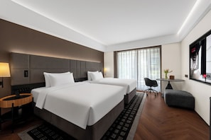 A hotel room with two beds, a desk, a chair, and a large window with curtains. - Intercity Hotel Lijiang Dashuiche (Lijiang)