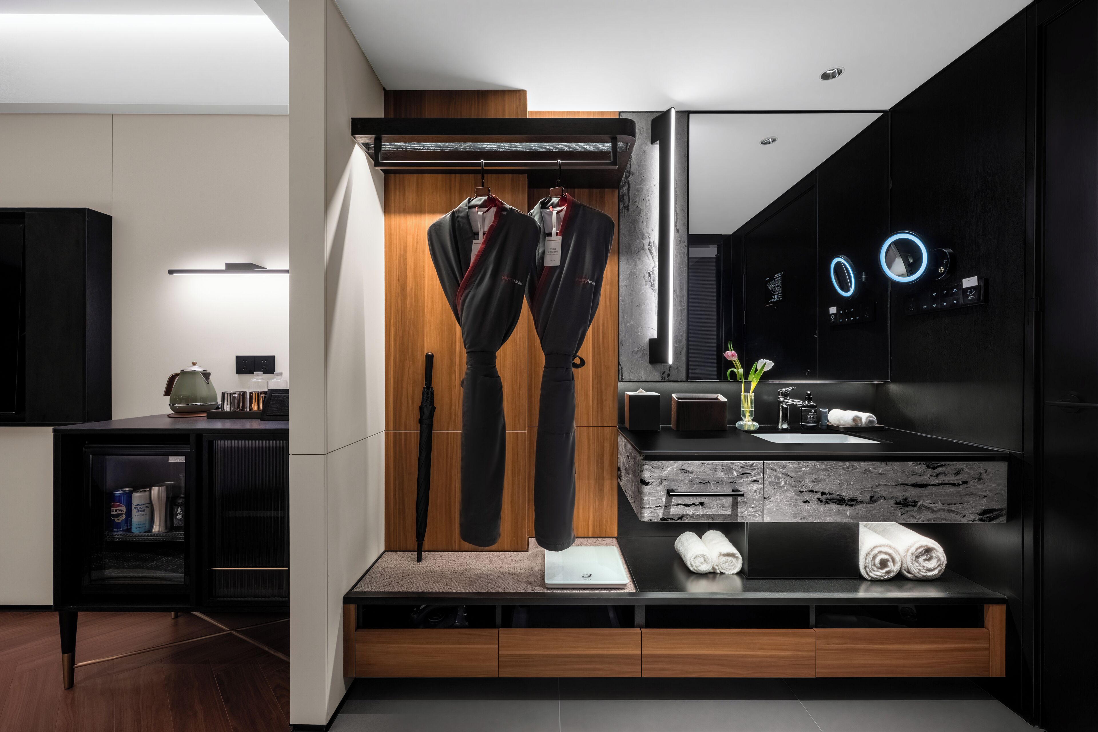 A modern bathroom with a large mirror, a towel rack, a sink, and a shower area.