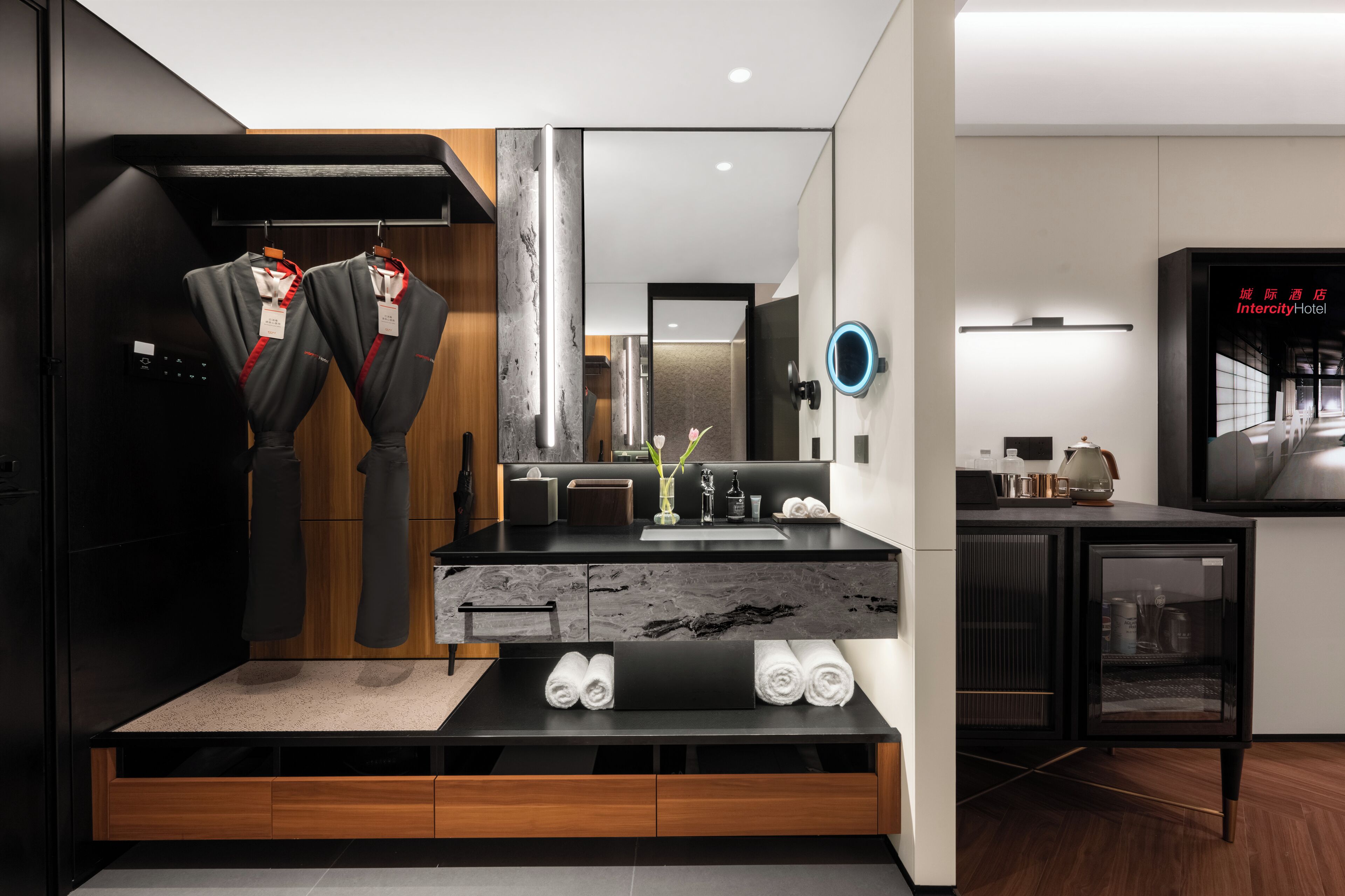 A modern bathroom with a large mirror, a black vanity, and a wooden cabinet.