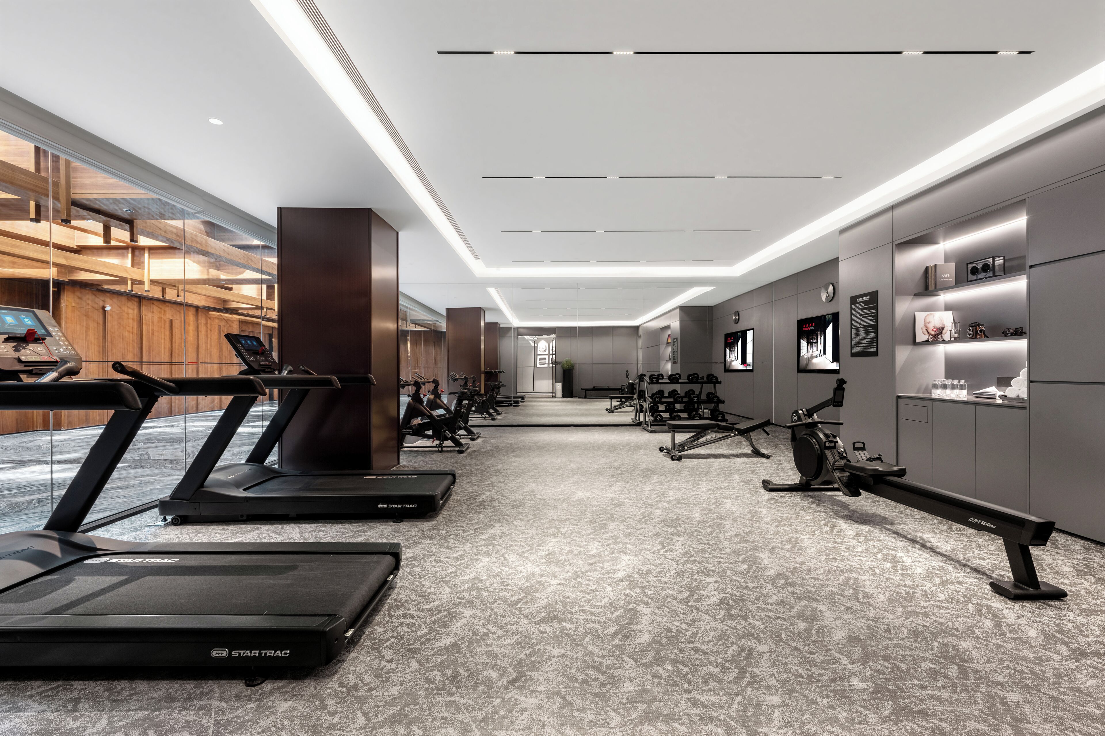A modern gym with treadmills, stationary bikes, and weight machines.