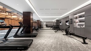 Academia moderna com esteiras, bicicletas ergométricas e máquinas de musculação.