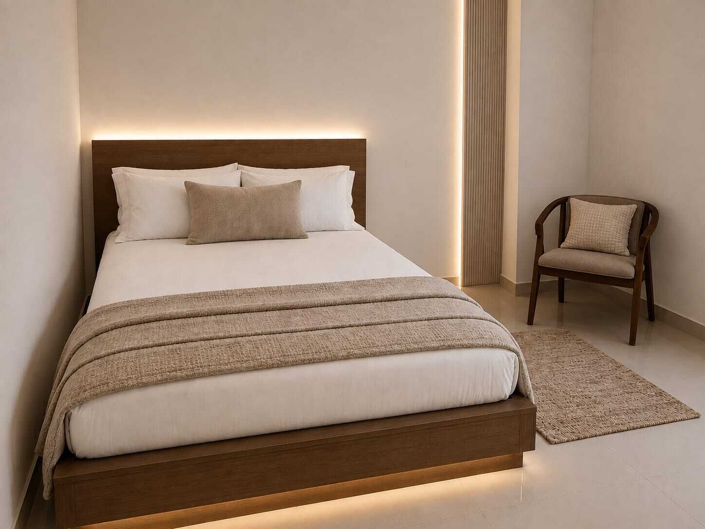 A modern bedroom with a bed, a chair, and a bedside table.
