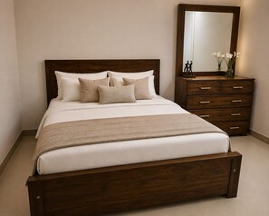 A bed with a wooden headboard, multiple pillows, a bedside table with a mirror, and a dresser with drawers.