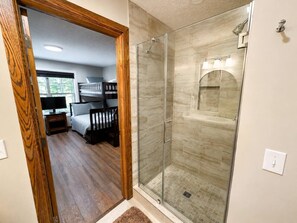 A room with a glass-enclosed shower, a bed with a headboard, and a window. - BBC 12 Snowshoe Ski in out 5BR Home Near Slopes (Snowshoe)