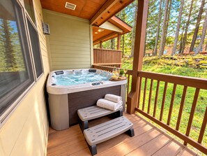 A hot tub on a wooden deck with steps leading up to it, surrounded by a wooden railing and a view of trees. - BBC 12 Snowshoe Ski in out 5BR Home Near Slopes (Snowshoe)