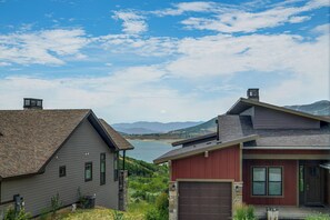 Ein Wohngebiet mit Häusern, einer Garage und Blick auf einen See und Berge.