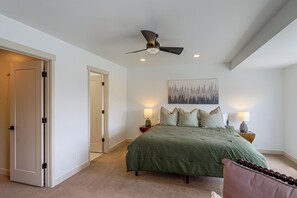 A bedroom with a bed, two bedside lamps, a ceiling fan, and a painting on the wall. - Hot Tub, Mtn & Lake Views! Group Abode in Daniel (Daniel)