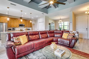 A spacious living area with a leather sectional sofa, a glass coffee table, and a kitchen in the background. - 6 Mi to Port Charlotte Beach Park! Family Getaway (Port Charlotte)