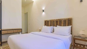 A bedroom with a bed, bedside tables, and a wooden headboard.
