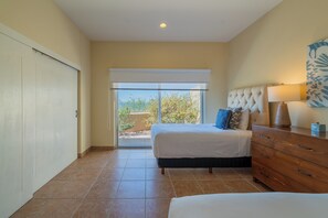 A bedroom with a bed, a dresser, and a window with a view of trees.