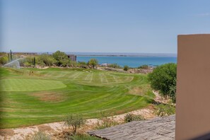 A golf course with a view of the ocean and a clear sky.