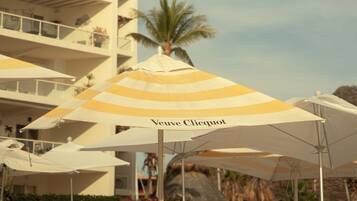 A hotel with multiple white umbrellas, one with 'Veuve Clicquot' branding.