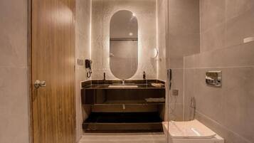Een moderne badkamer met een houten deur, een grote spiegel, een wastafel en een douchehoek.