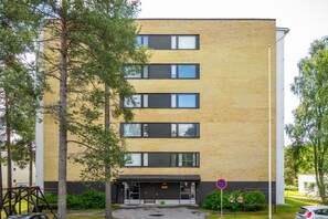 A multi-story building with a brick facade, a gated entrance, and a no parking sign. - Pondside City Flat By Lapland Host (Rovaniemi)