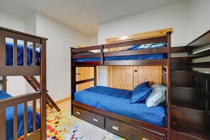 A bunk bed with a wooden frame, a lower bunk with a blue mattress, and a top bunk with a wooden headboard. - Kennewick Hideaway: Yard, Deck, 2 Living Rooms (Kennewick)