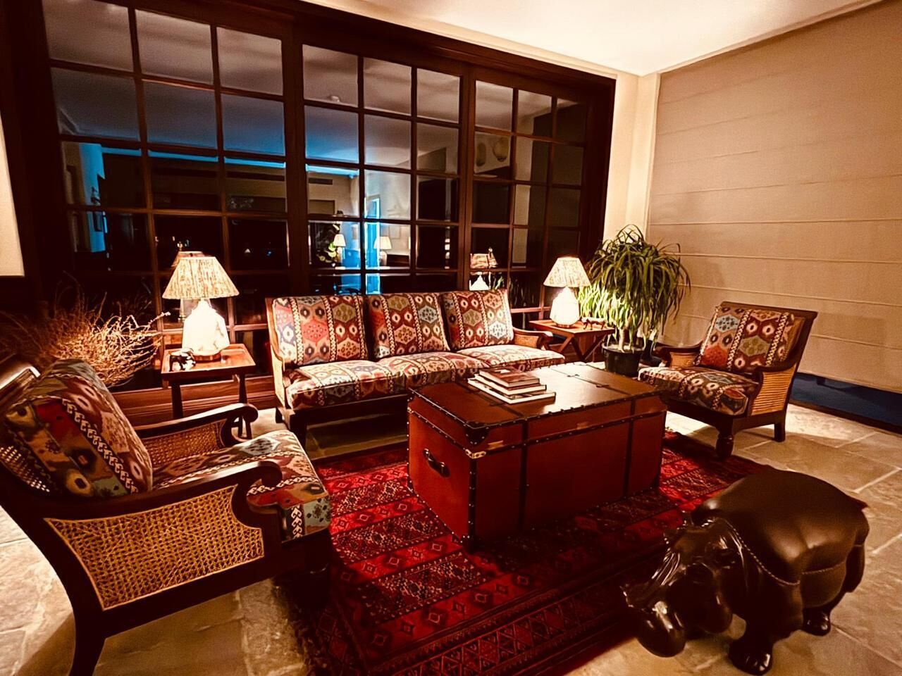 A cozy living room with a sofa set, a coffee table, and a leather dog statue.