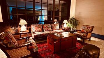 A cozy living room with a sofa set, a coffee table, and a leather dog statue.