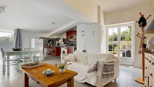 Una sala moderna con comedor, cocina y vistas al exterior.