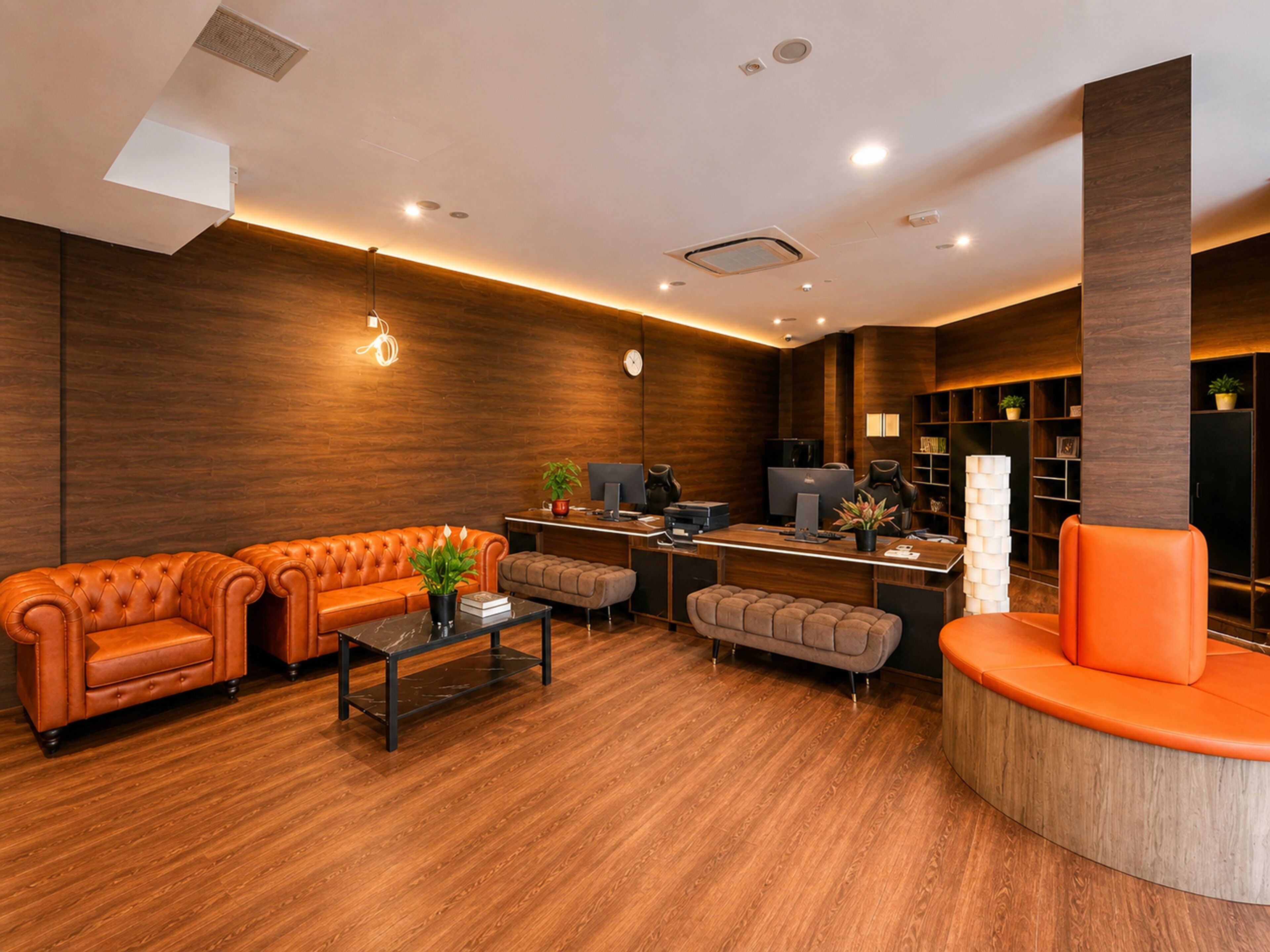 A modern lobby with a sofa, ottoman, and a curved seating area.