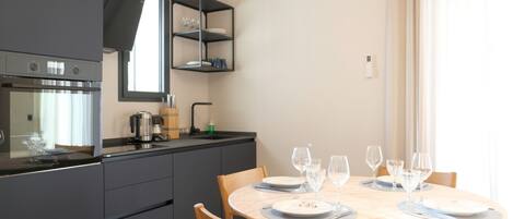 A modern kitchen with a built-in oven, a coffee maker, and a wine rack.