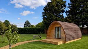 A small, single-story wooden structure with a curved roof, a door, and a small porch area.